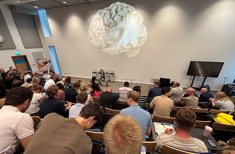 Deelnemers in collegezaal squatten met Erik Scherder.