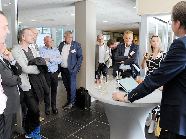 Een van de ondernemers licht zijn idee toe aan een groep deelnemers tijdens Podium en deelnemers in de zaal tijdens het Open Podium van de werkgroep Accounttech op 13 juni 2019