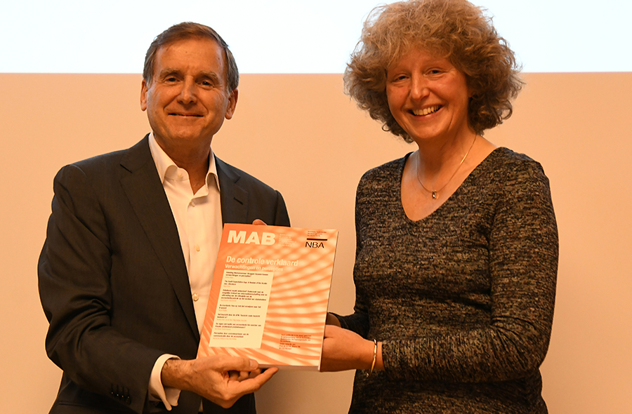 Barbara Majoor (AFM/Nyenrode) en Paul Koster, directeur van beleggersvereniging VEB met een exemplaar van de MAB-uitgave 'De controle verklaard'
