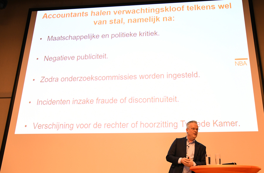 Marcel Pheijffer op het podium met scherm tijdens de presentatie van de MAB-uitgave 'De controle verklaard'