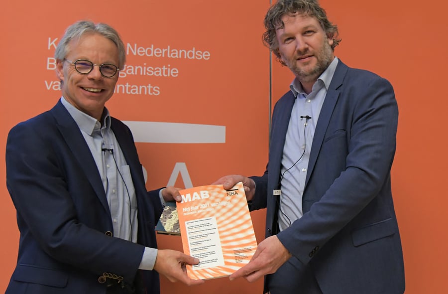 Kris Douma en Arjan Brouwer met een exemplaar van 'Het jaar 2021 verslagen'